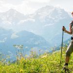 Female hiker in front of Eiger, Monch and Jungfrau mountains