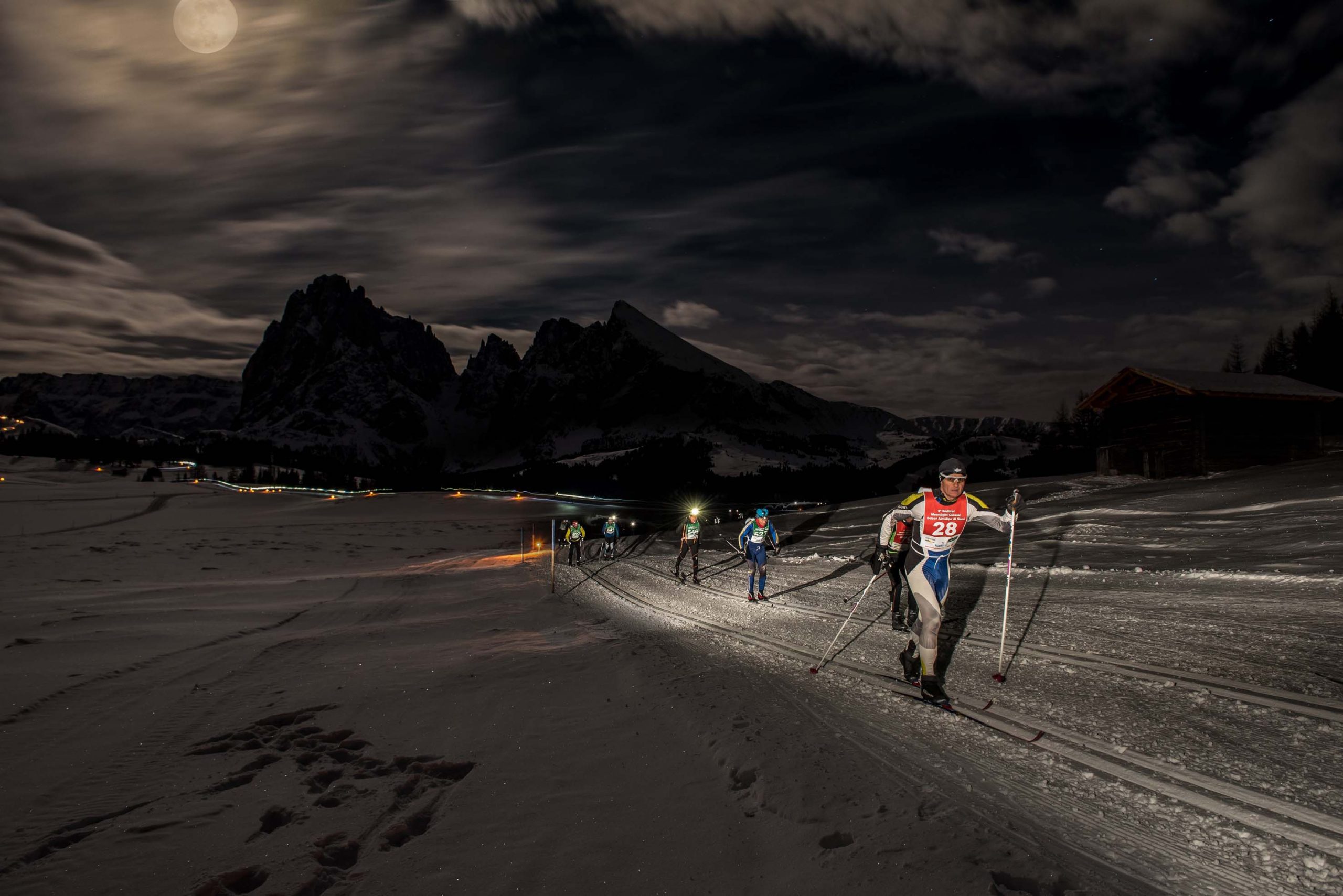 Soltanto le torce e la luna piena illuminano i fondisti (foto Armin Mayr)